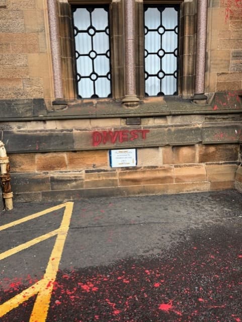 Red graffiti vandalism on Gilbert Scott Building stonework before cleaning