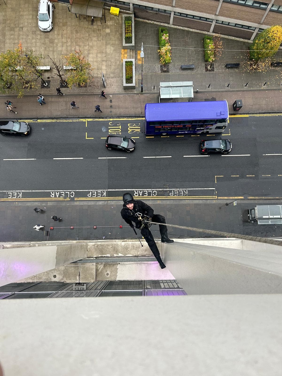 Aerial view of rope access technician working at height above Glasgow street