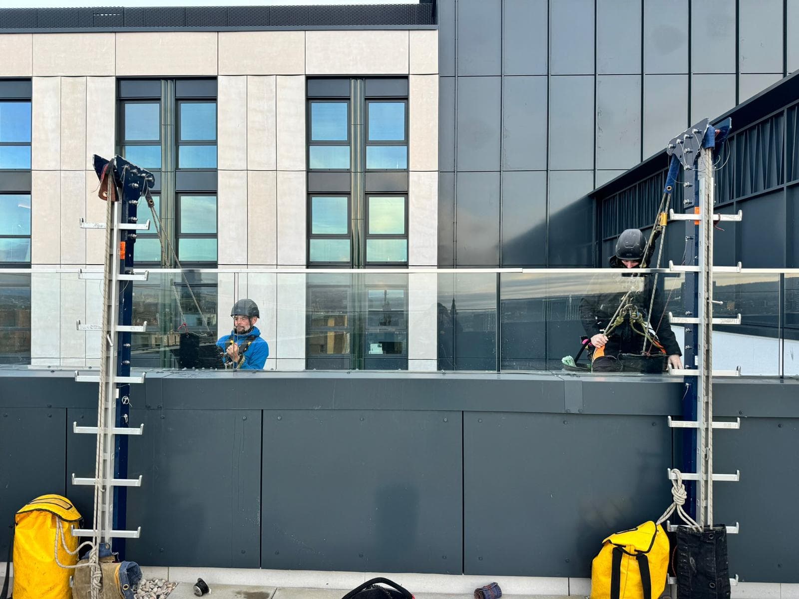 Two-man rope access team setting up rigging equipment