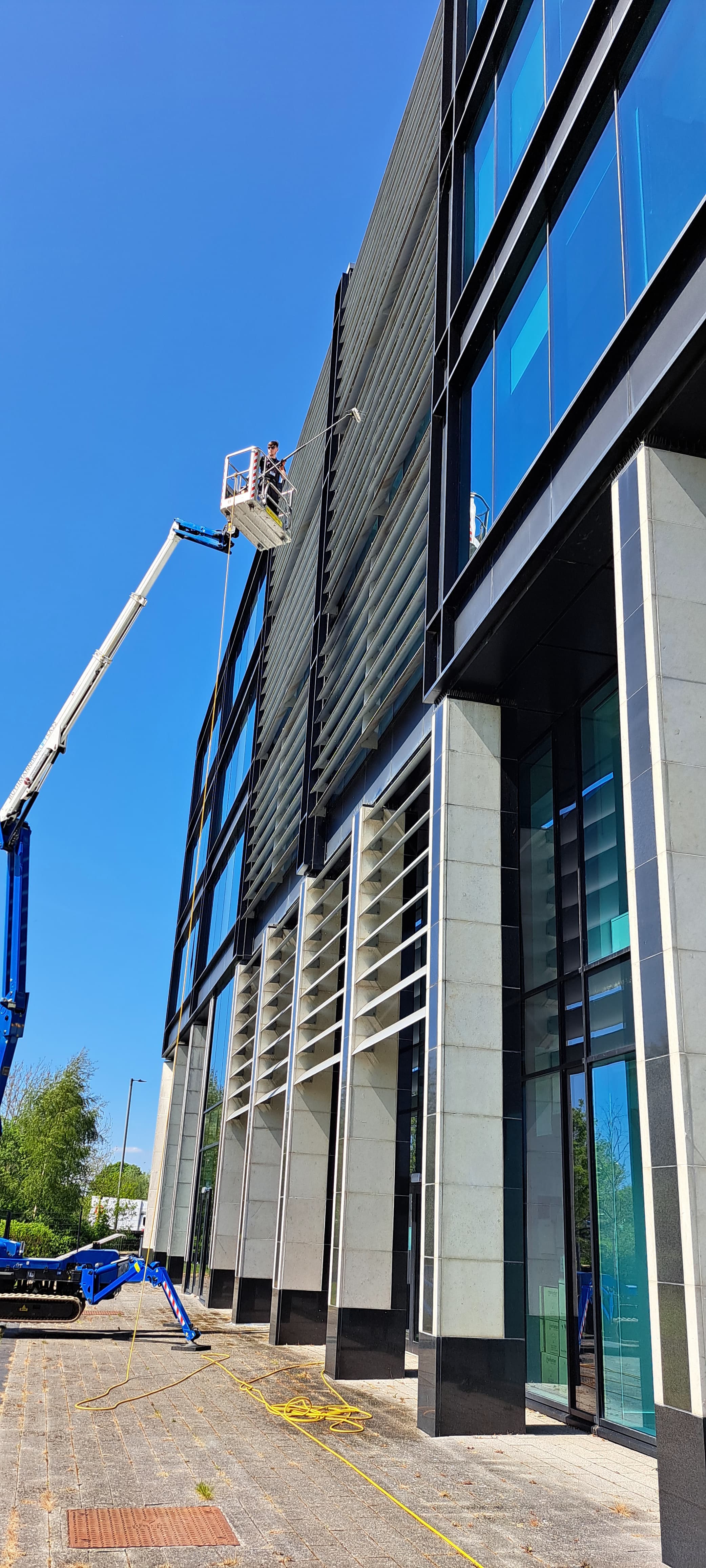 MEWP platform alongside a modern commercial facade