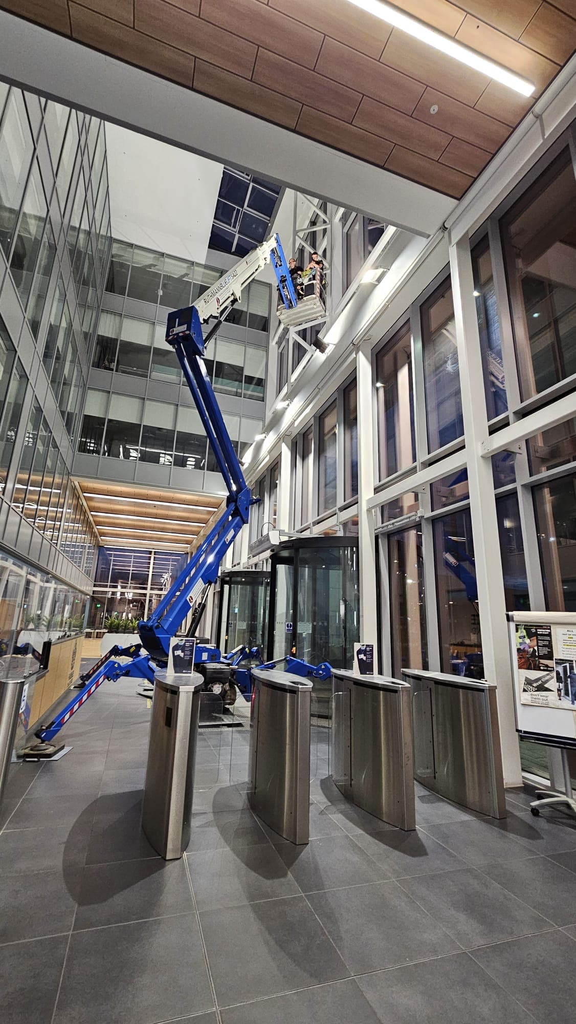 Spider lift window cleaning in modern commercial atrium