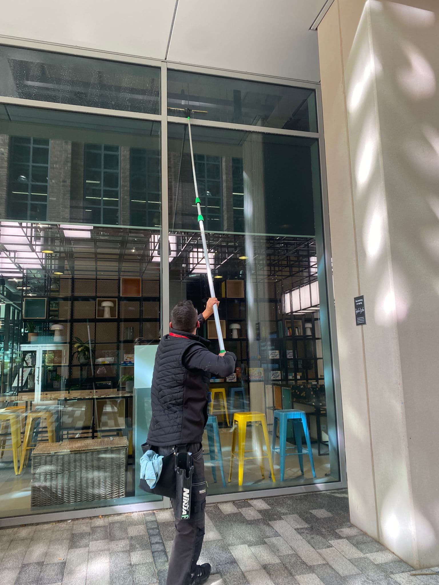 Water-fed pole window cleaning on commercial building